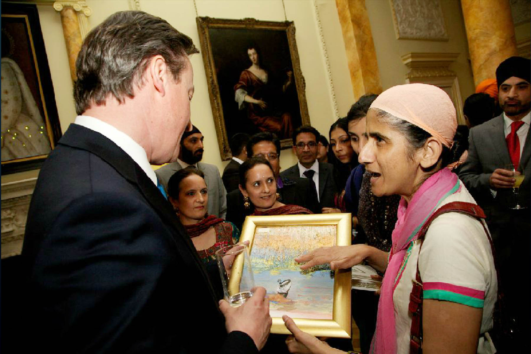  Prime Minister David Cameron receiving oil painting of Sikh praying in Darbar Sahib sarovar from Mejindarpal Kaur, United Sikhs director